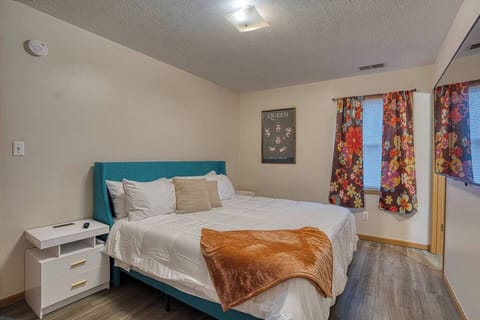 Peaceful bedroom with a plush king bed, soft linens, and blackout curtains for a restful night’s sleep.