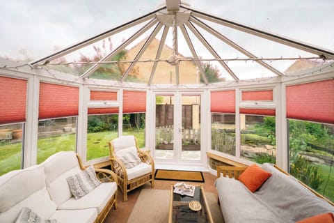 A light-filled conservatory with classic wicker armchairs with plush cushions for pure relaxation