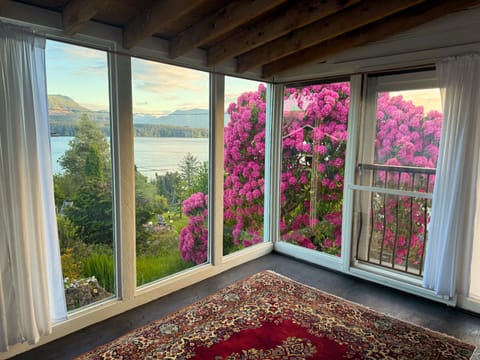 Sunroom with ocean, mountain, and garden views
