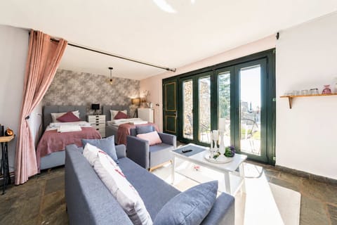 Large doors open the living space toward the terrace and gardens, bringing natural light and fresh air into the studio all day long.
