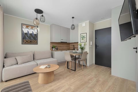 An open living area connected to a modern kitchen with clean lines and wood accents. The layout feels spacious and well-organized for everyday living.