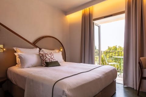 King bed with a fabric headboard and park-view glass door — step-free access throughout