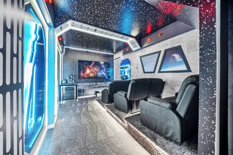 Experience a themed entertainment room with plush black recliners and stunning starfield ceilings for a cozy, immersive movie night. The vibrant decor and futuristic wall art create a fun atmosphere for you to relax and enjoy.