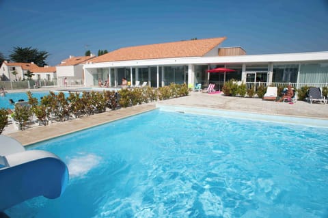 The outdoor pool with its water slide is the heart of the residence during the summer season.