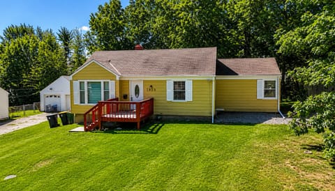 Charming cottage-style home with a spacious lawn and deck.