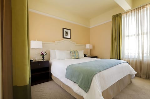 Stretch out on a plush bed beside softly filtered daylight.