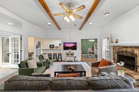 Bright and spacious living area with high ceilings and a cozy fireplace—perfect for relaxing or gathering after a full day out exploring the city.