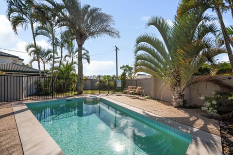 Sparkling in-ground pool with tropical palm views.