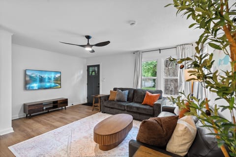 Bright, stylish living room with large windows and cozy seating