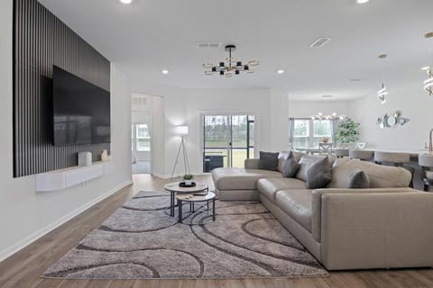Bright, open living room w/ hardwood floors & modern furnishings — made for relaxing.