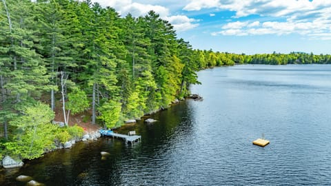View of waterfront including private dock, swimming platform, and kayaks