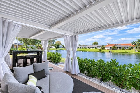 Shaded waterfront patio lounge with cozy daybeds and tranquil lake views.