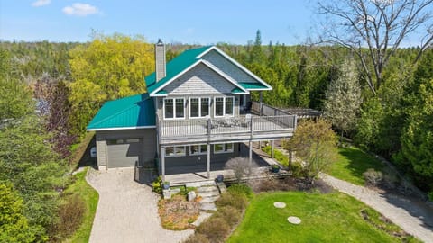 Stunning exterior view featuring large wraparound decks and peaceful privacy. 