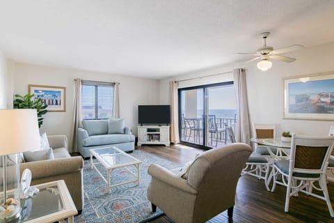 Sunlit living room with cozy seating and balcony views