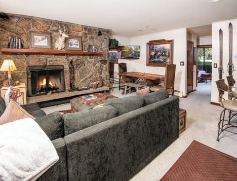Curl up by your roaring stone fireplace in this inviting living room, where rustic charm meets mountain elegance and every detail invites you to unwind in comfort.