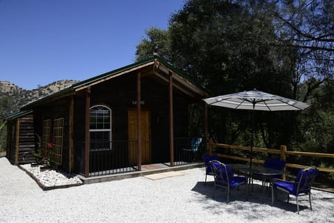 Outdoor dining and lounge seating for four under an umbrella.