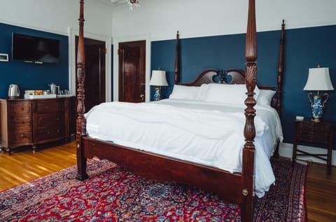 Elegant four-poster bedroom with rich wood details and classic charm