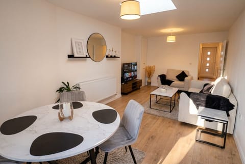 Open plan living and dining glows under a bright skylight by the entrance