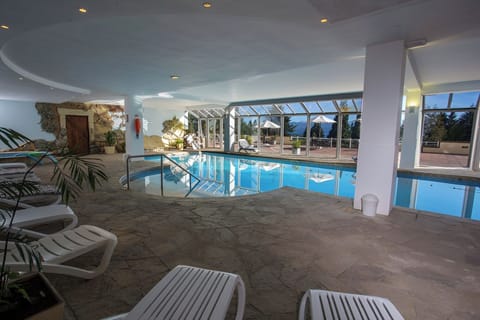 Unwind on loungers beside sparkling water and mountain views.