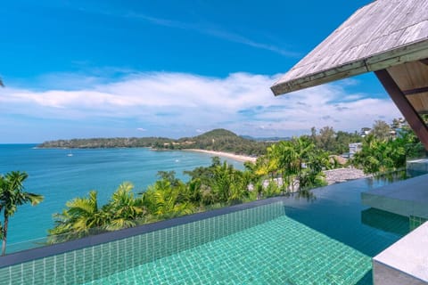 Oceanfront infinity pool surrounded by tropical gardens at luxury Phuket villa near Surin Beach