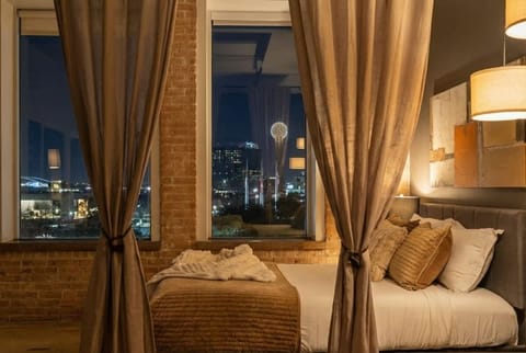 Wake up to Reunion Tower and downtown Dallas skyline views through floor-to-ceiling windows. Industrial brick meets modern luxury in this iconic loft.