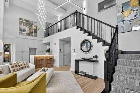 Open-concept living space featuring dramatic staircase.