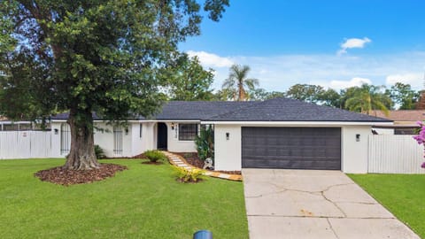 Charming Orlando villa exterior with lush lawn & large tree