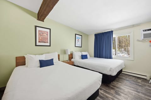 The bedroom retreat offers a pair of plush queen beds & a TV​