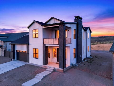 Modern mountain-view exterior glowing at sunset with a private balcony and garage.