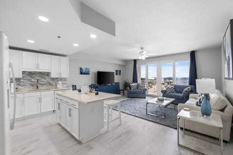 Relax in your bright, open living space with stylish coastal touches, a full kitchen, and balcony access overlooking the waterfront—perfect for unwinding after a day of exploration.