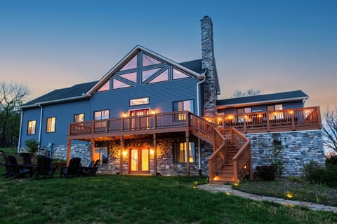 Spacious mountain retreat with a lit deck, stone fireplace, and sunset views