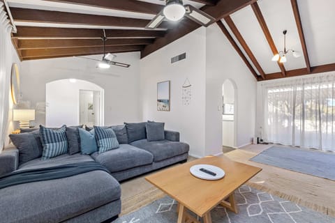 Relax in this bright and spacious living area featuring high vaulted ceilings, cozy seating, and a warm, inviting atmosphere. 