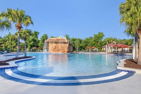 Unwind in a wide, sunlit pool with waterfall views.