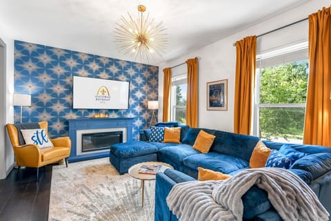 Gather in the main floor Legends Lounge featuring a designer sectional, fireplace, record player, and St. Louis-inspired decor.