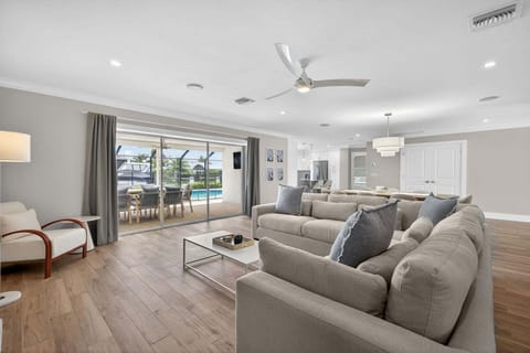 Living area with plush sectional sofa and a slider access to private lanai and pool