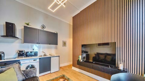 BRIGHT AND STYLISH LIVING AREA WITH SMART TV AND COMFORTABLE SEATING