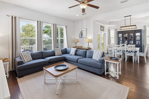 Sink into the plush sectional and let the coastal breeze flow through as sunlight fills your open-concept living and dining space, perfect for gathering with loved ones.