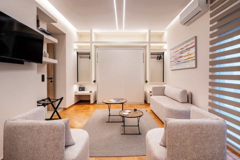 The bright living area brings together comfortable seating, contemporary design, and natural light, creating a welcoming space to relax, socialise, or plan your next day in Athens.