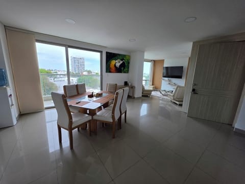 Bright open-plan lounge with city views, balcony doors, and smart TV