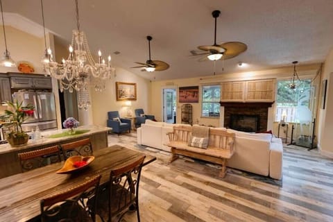 The spacious Great Room features an inviting open floor plan. Sink into the oversized plush couch wrapped in soft throws, or gather around the striking electric flame fireplace. A hidden TV elegantly appears behind sliding doors when needed.