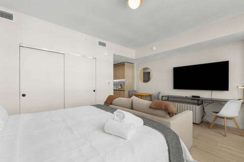 Studio Suite: The actual private unit in one view, with a king bed, sofa, dining table, TV, workspace, and compact kitchenette.