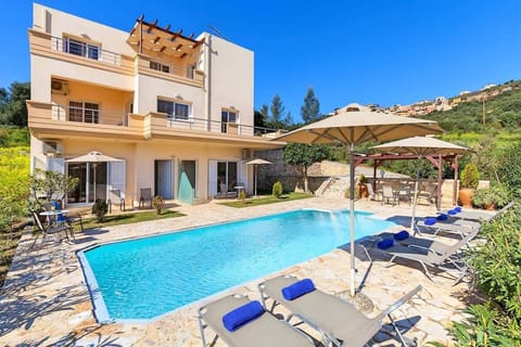 Stylish accommodation with access to a spacious shared pool, sun loungers, and open-air relaxation areas.