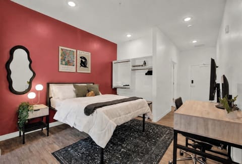 Modern bedroom with bold accent wall, workspace, and cozy designer touches