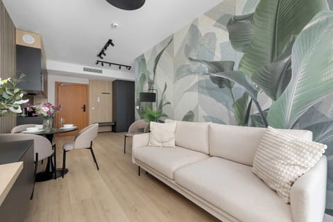 Elegant living area featuring a comfortable sofa, modern furnishings, and a striking botanical wall mural.
