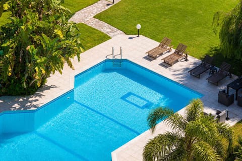 Large shared swimming pool with sunbathing areas, perfect for cooling off during warm summer days and relaxing under the Greek sun.