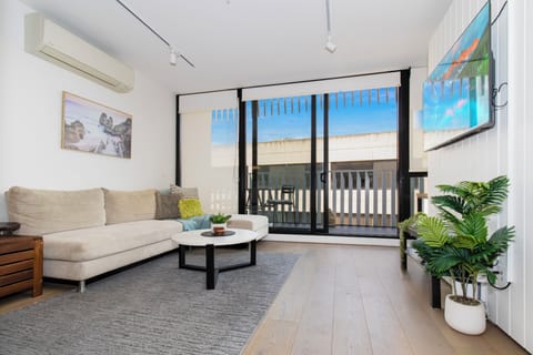 Bright modern lounge with balcony, AC, and plenty of natural light