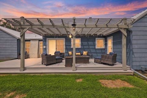 Relax outdoors on a pergola deck with spacious seating and gas fire pit in this Waldo Kansas City vacation rental.