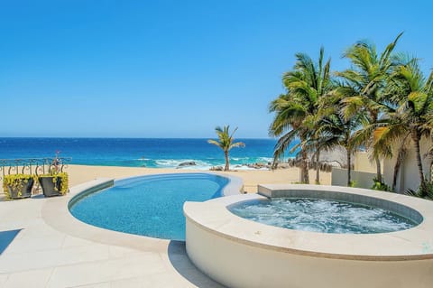 Soak in your private hot tub steps from the pool, with swaying palms, golden sand, and endless turquoise ocean stretching before you—pure beachfront bliss.