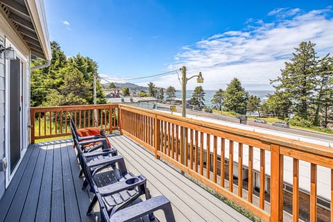 Relax on your private deck with Adirondack chairs and panoramic ocean views framed by coastal trees and mountain silhouettes—perfect for morning coffee or watching the waves.