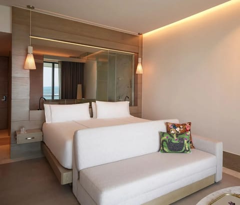 Unwind in a serene suite with warm lighting and plush bedding.